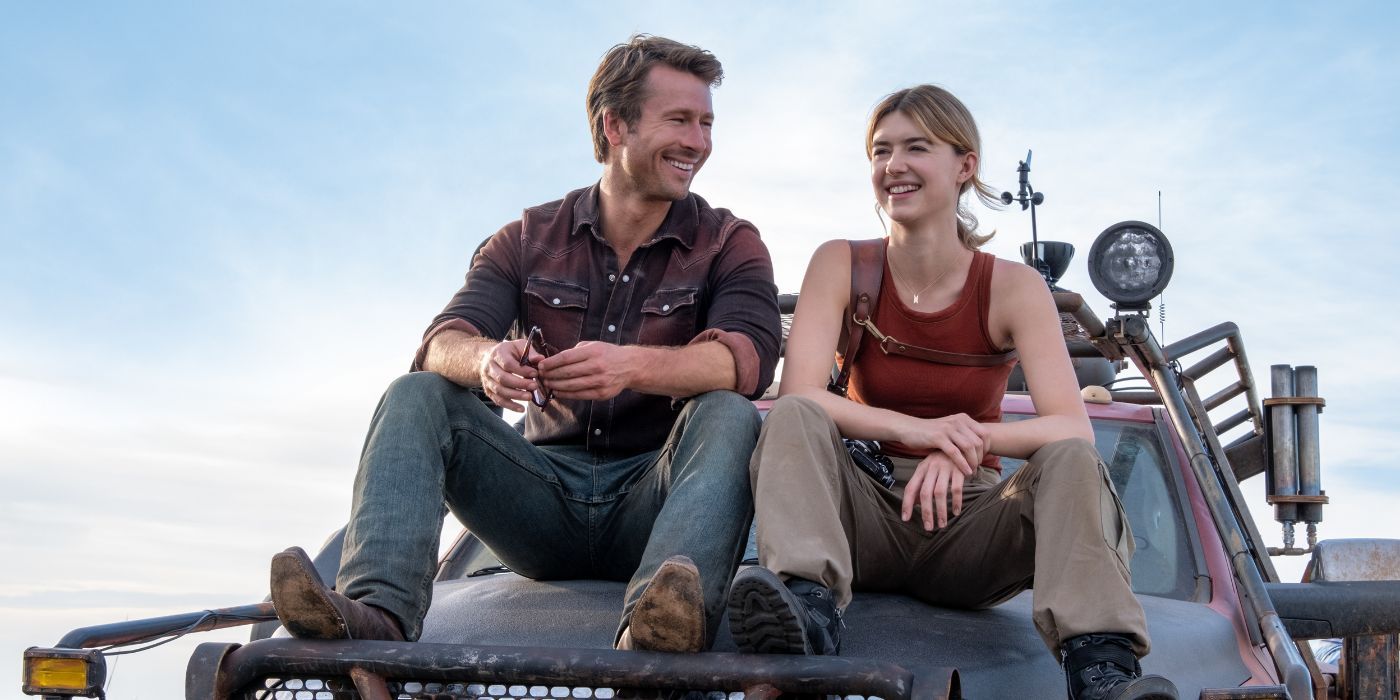 Glen Powell y Daisy Edgar-Jones mientras Tyler y Kate se sientan y sonríen encima de un camión a prueba de viento.