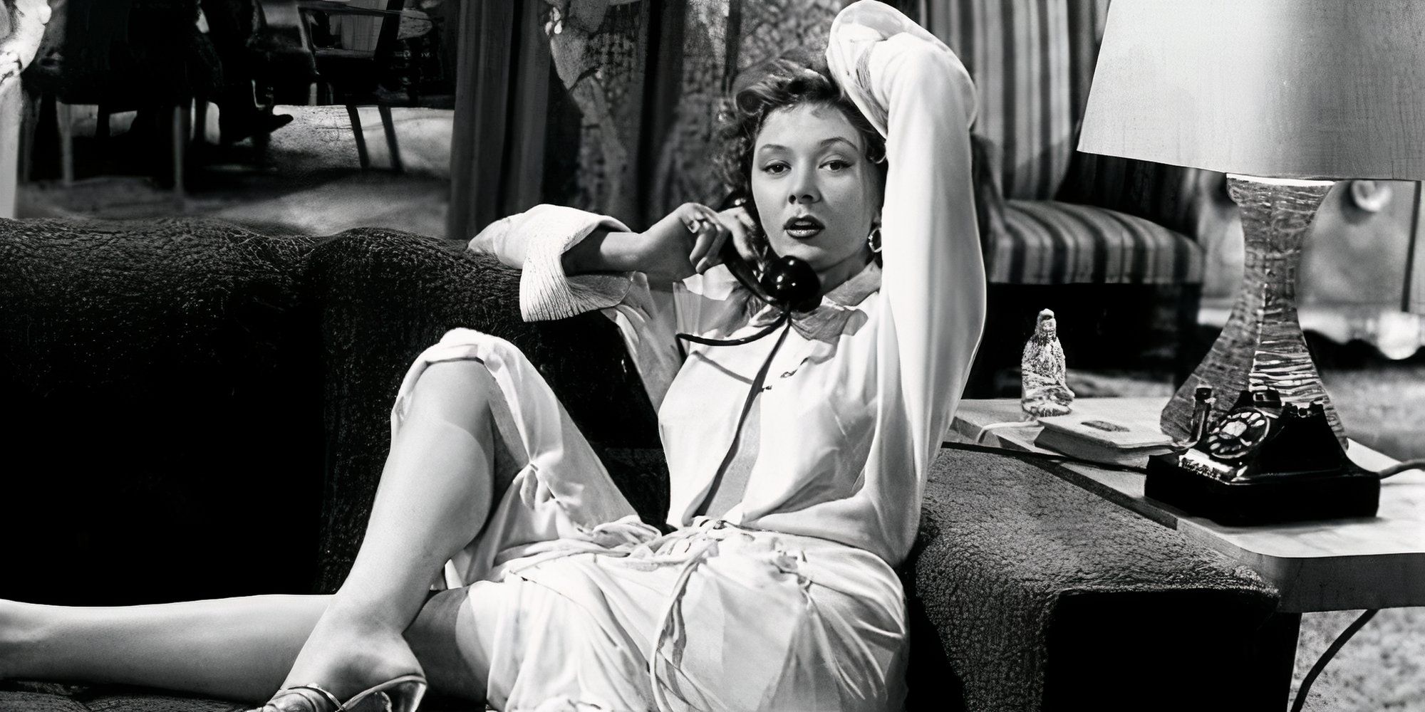 Gloria Grahame lying on a couch while on the phone in The Big Heat (1953)