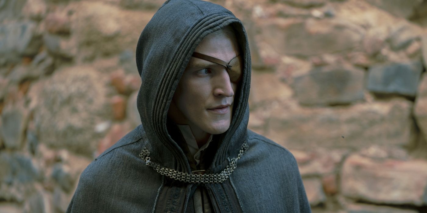 Ewan Mitchell as Aemond wearing a cloak and looking wary in House of the Dragon