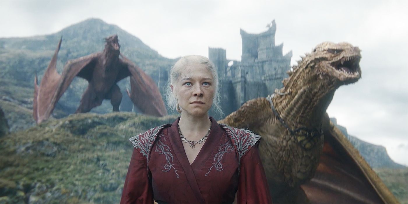 Daenerys Targaryen (Emilia Clarke) stands regally before two fierce dragons and a castle.