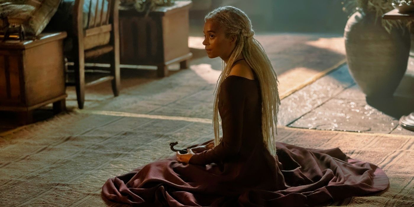 Phoebe Campbell sitting and holding a toy dragon in House of the Dragon Season 2