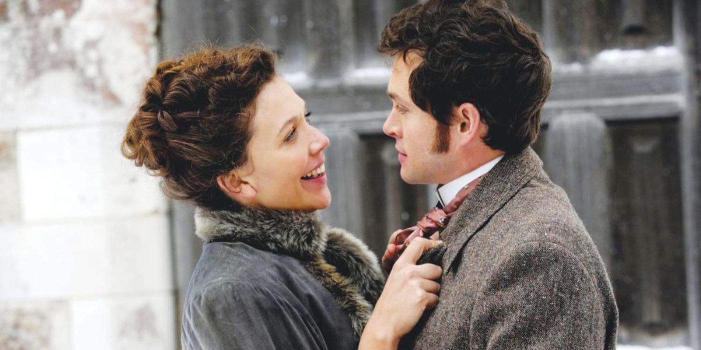 Charlotte (Maggie Gyllenhaal) smiles at Granville (Hugh Dancy) as they embrace each other lovingly.