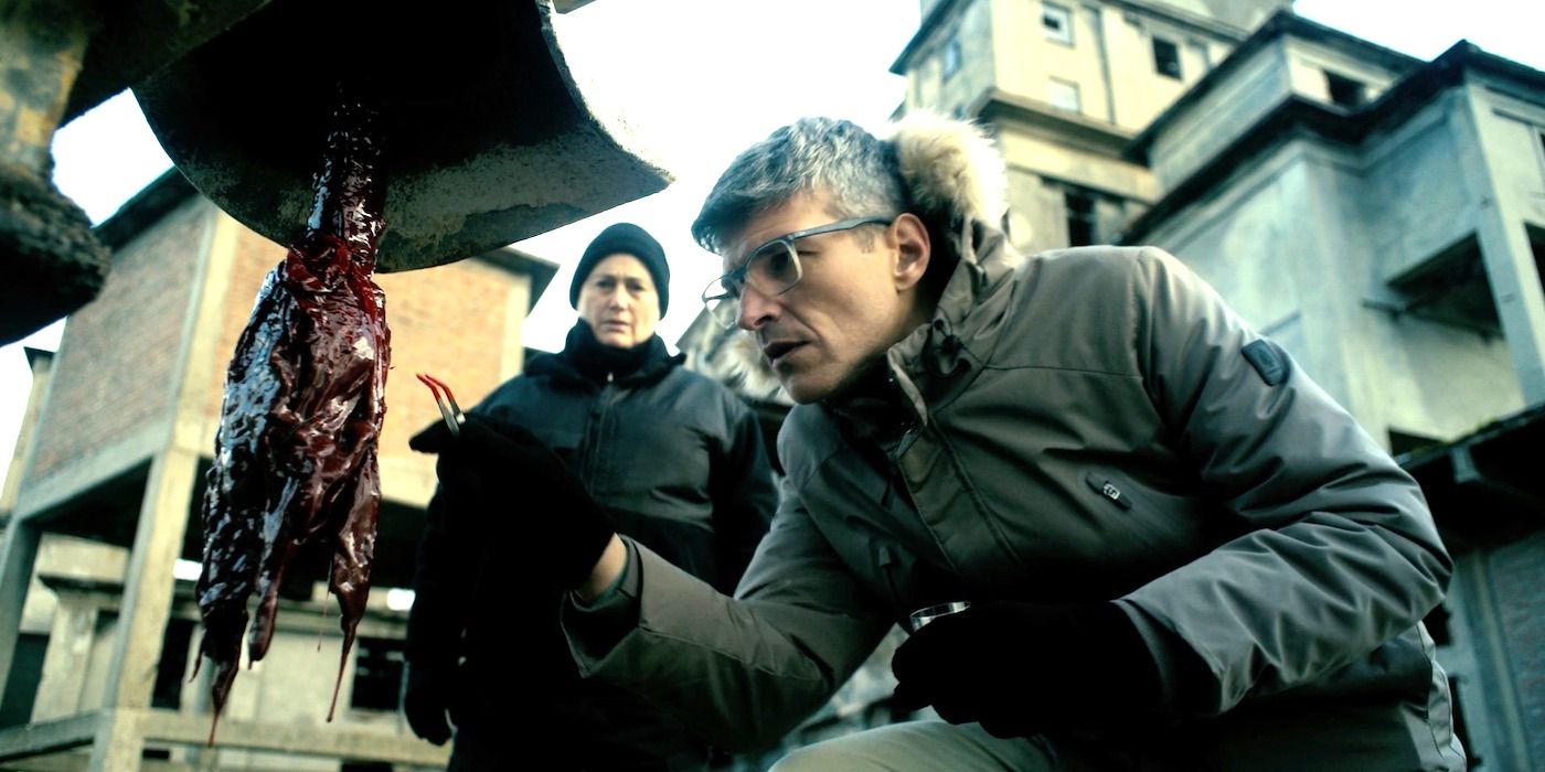 A man with glasses looks at a strange substance caught on a drill while a woman looks on in Hell Hole. 