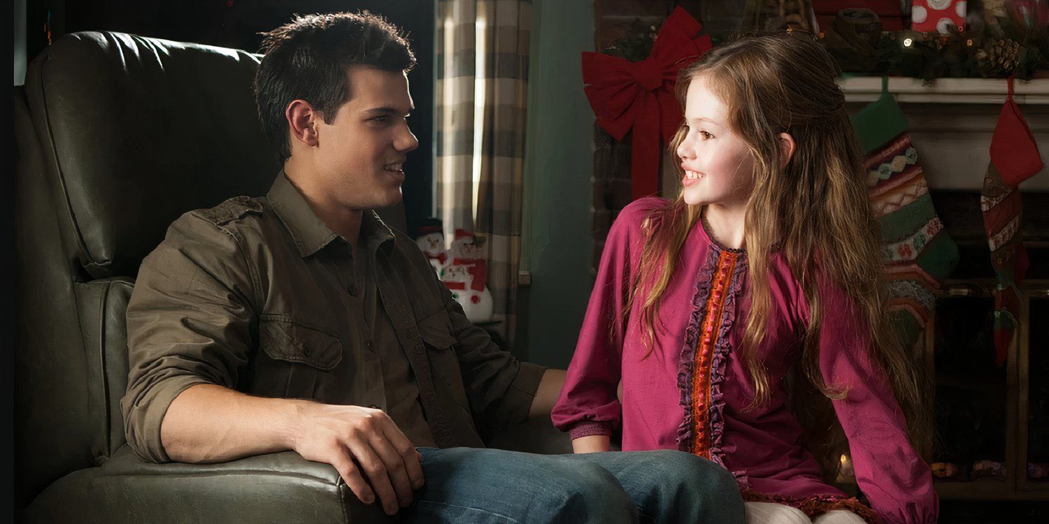 Jacob (Taylor Lawton) and Renesmee (Mackenzie Foy) sitting in an armchair together in Twilight Saga Breaking Dawn Part 2