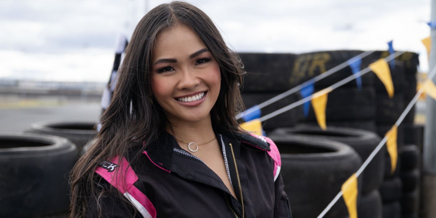 Jenn Tran smiling in front of a pile of car wheels in 'The Bachelorette' Season 21, Episode 3