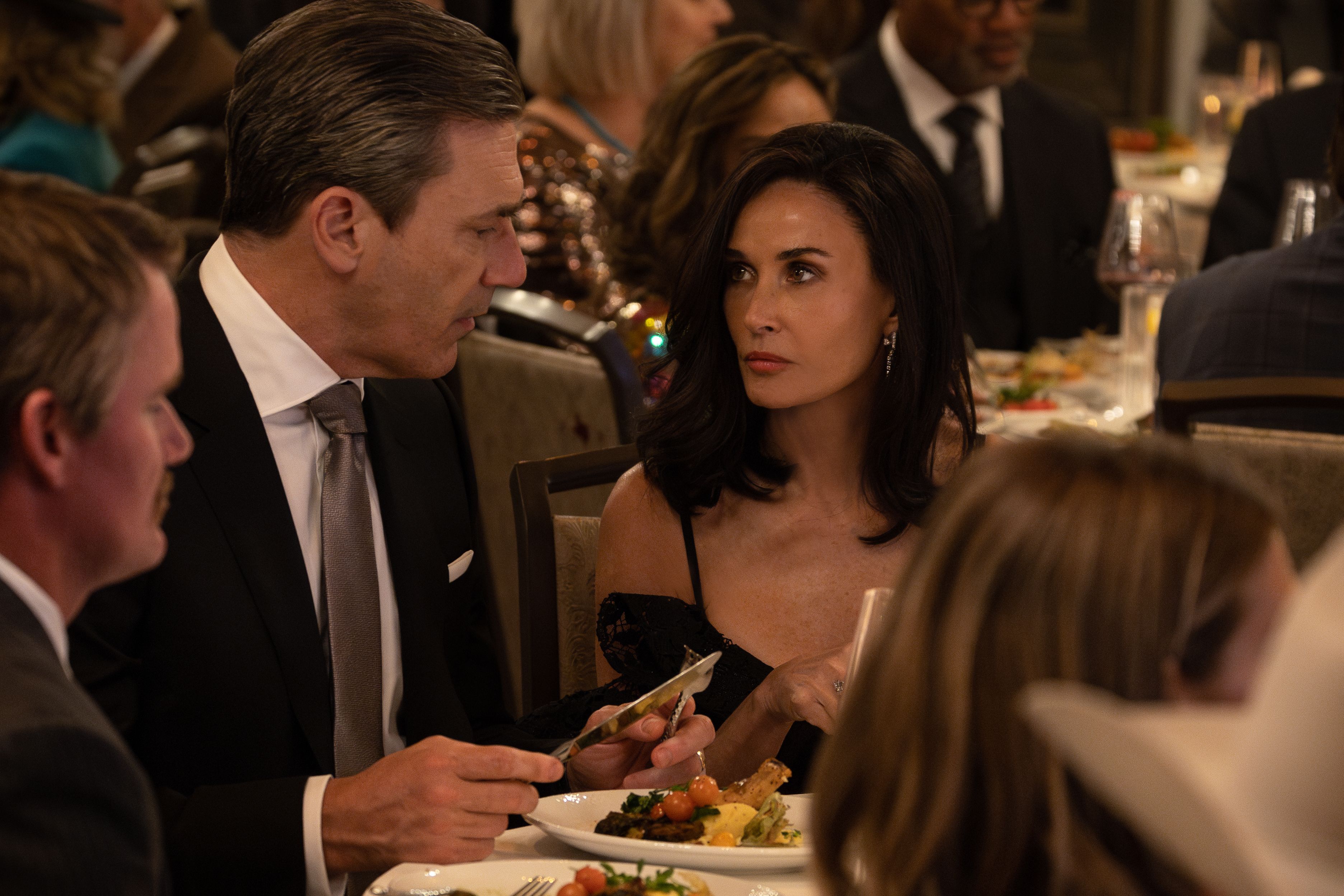 Demi Moore stares down Jon Hamm at a fancy dinner party in Landman
