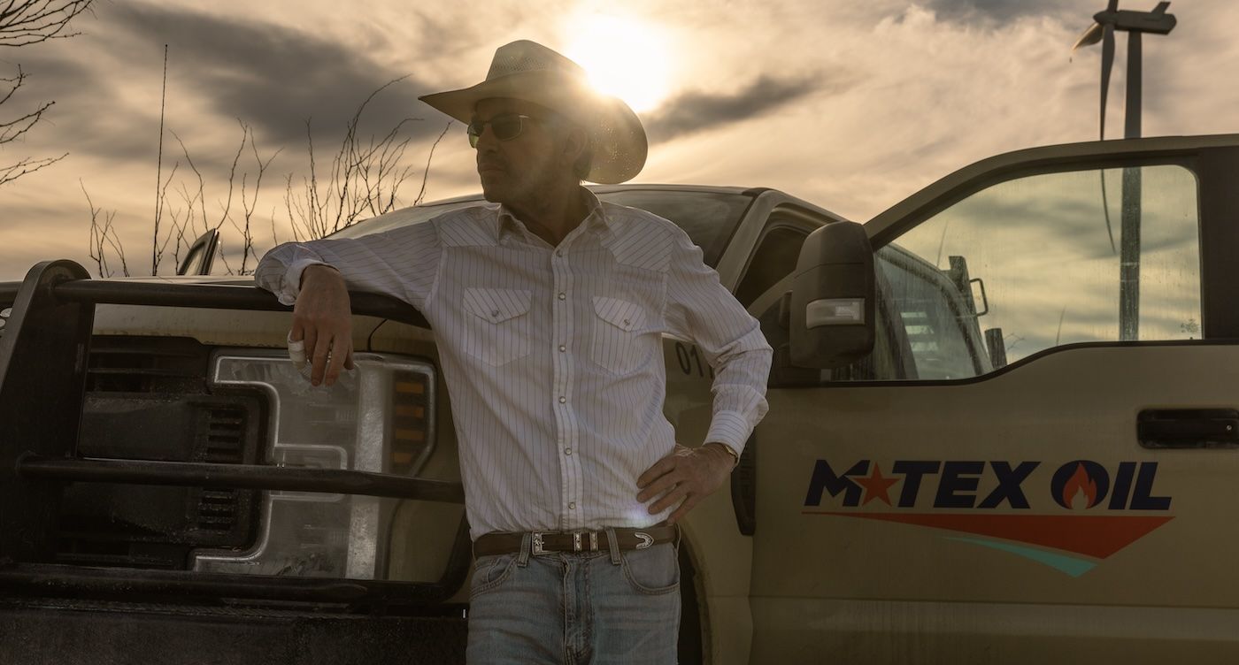 Billy Bob Thornton leans against a truck labelled M-Tex Oil in Landman 