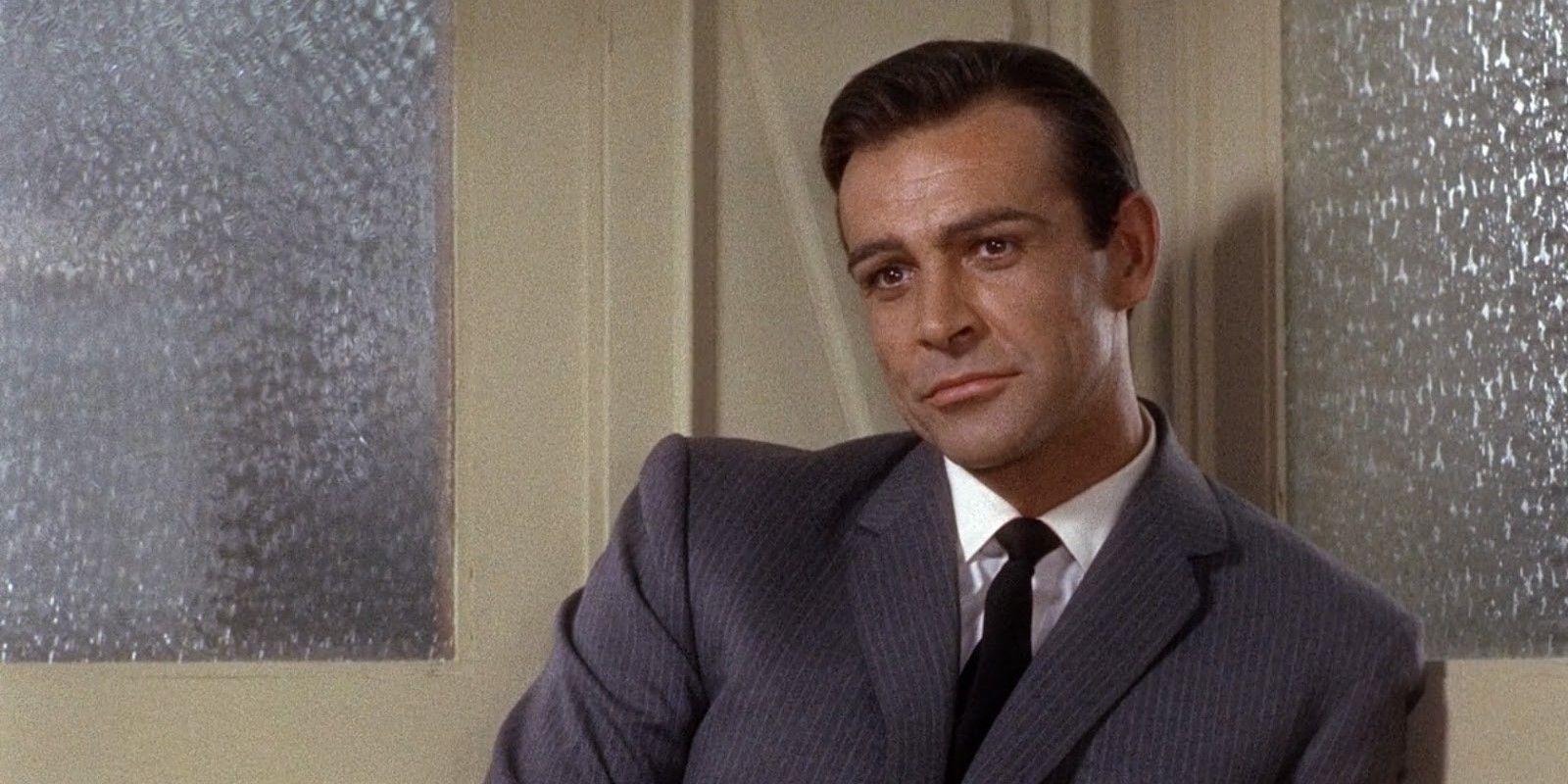 Sean Connery as Mark leaning on a door and looking at a person offscreen in &lsquo;Marnie&rsquo;