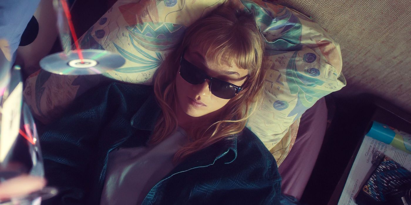 Megan Northam as Elsa Martens wearing sunglasses and laying in a bed in Meanwhile on Earth.