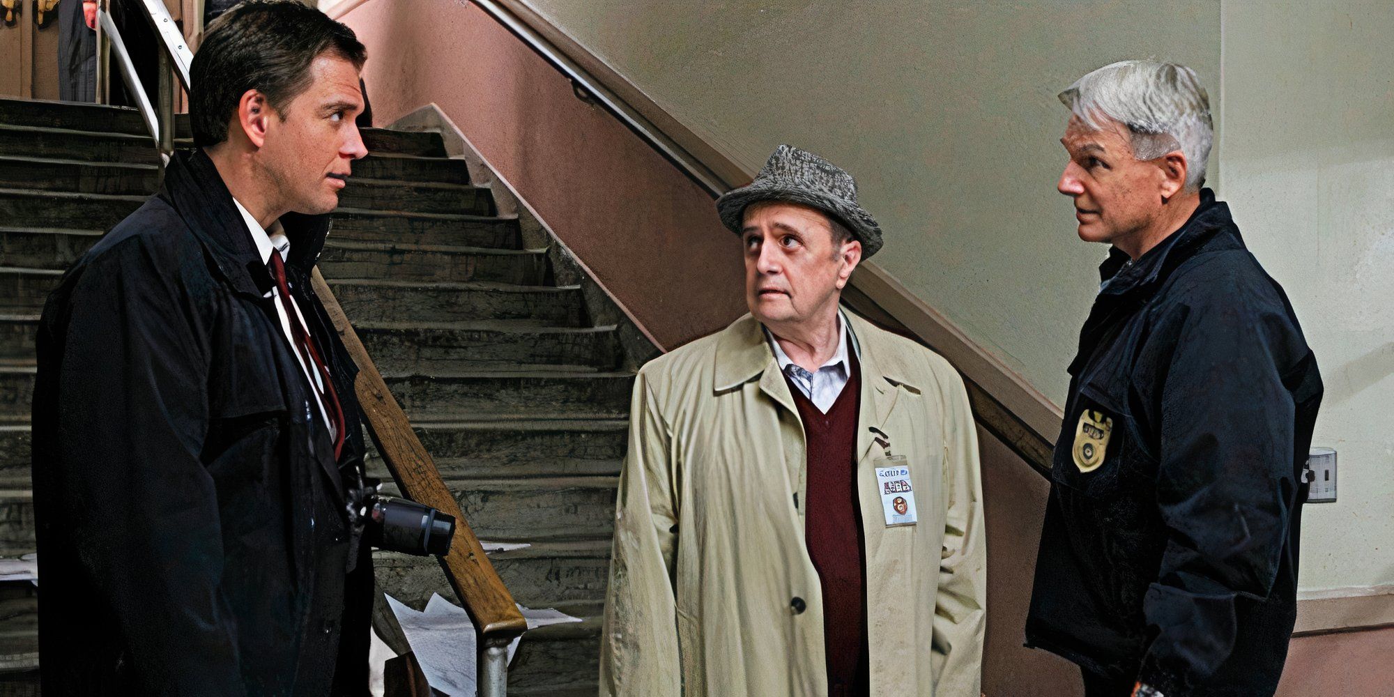 Michael Weatherly looking at Bob Newhart and Mark Harmon while standing at the foot of stairs in _NCIS