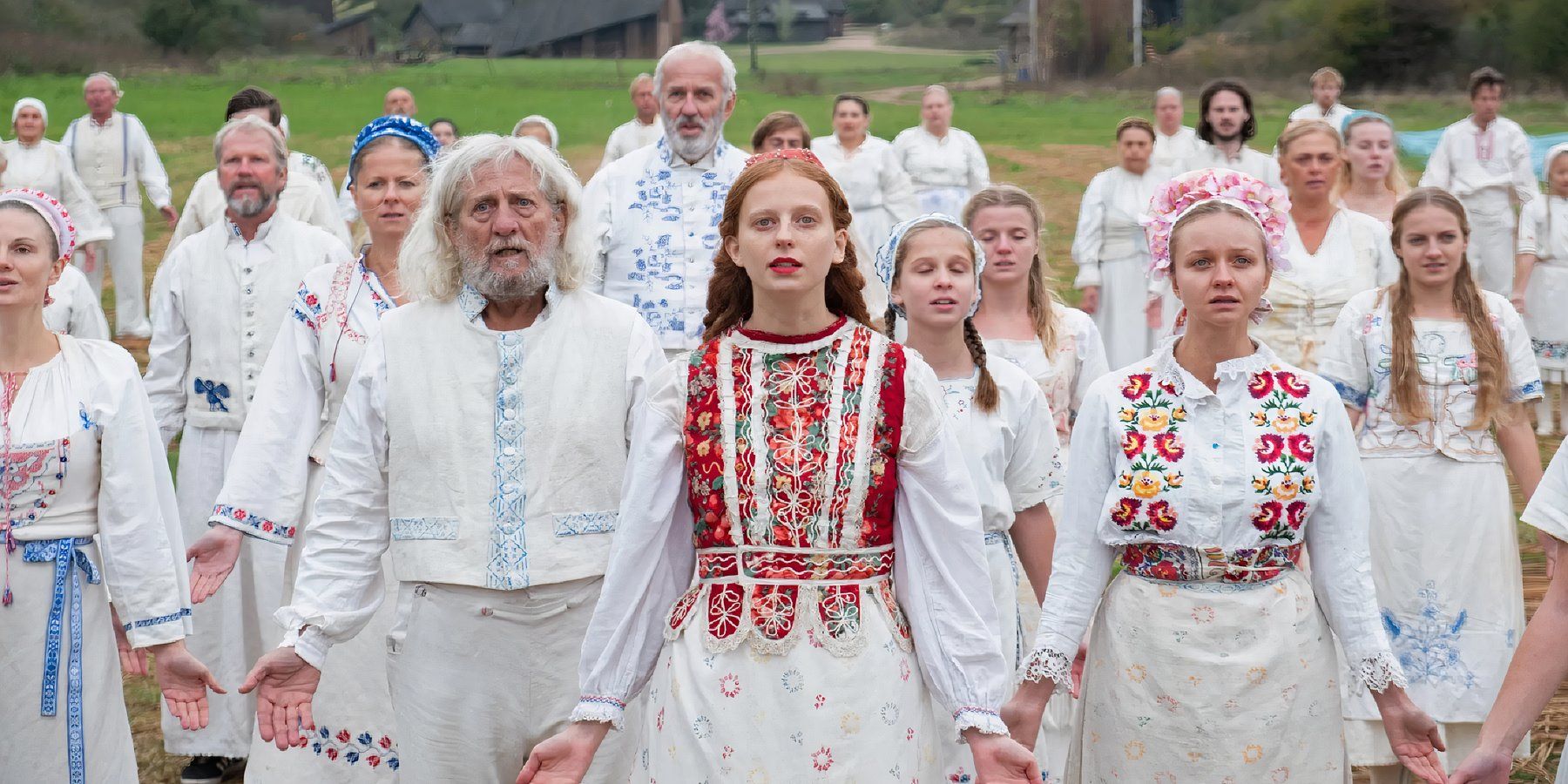 Los cultistas paganos bajan y extienden los brazos durante el ritual de Midsommar.