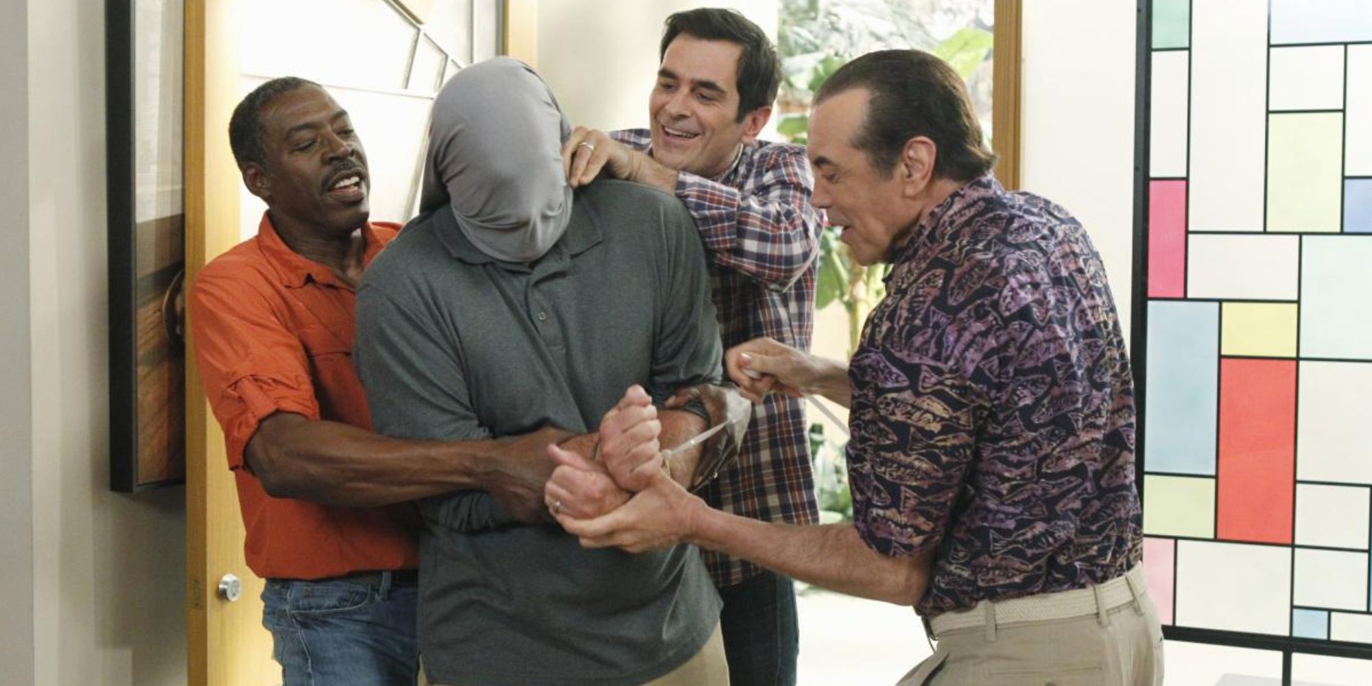 Phil Dunphy, Shorty and Miles put bag on Jay Pritchett's head in Modern Family