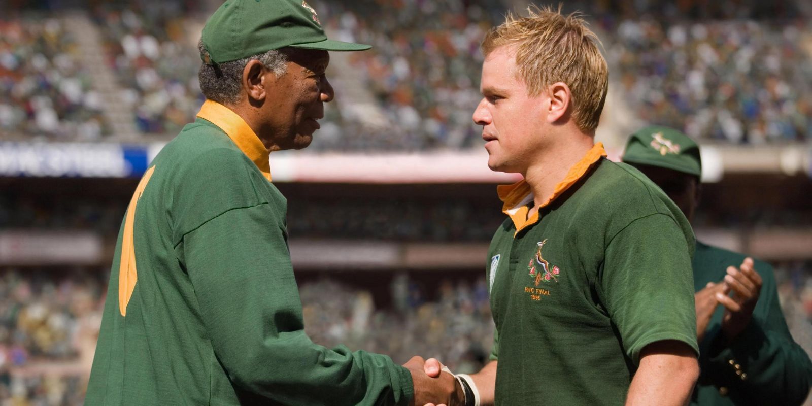 Morgan Freeman, que interpreta a Nelson Mandela en Invictus, le da la mano a Matt Damon, que interpreta al jugador de rugby Francois Pienaar.