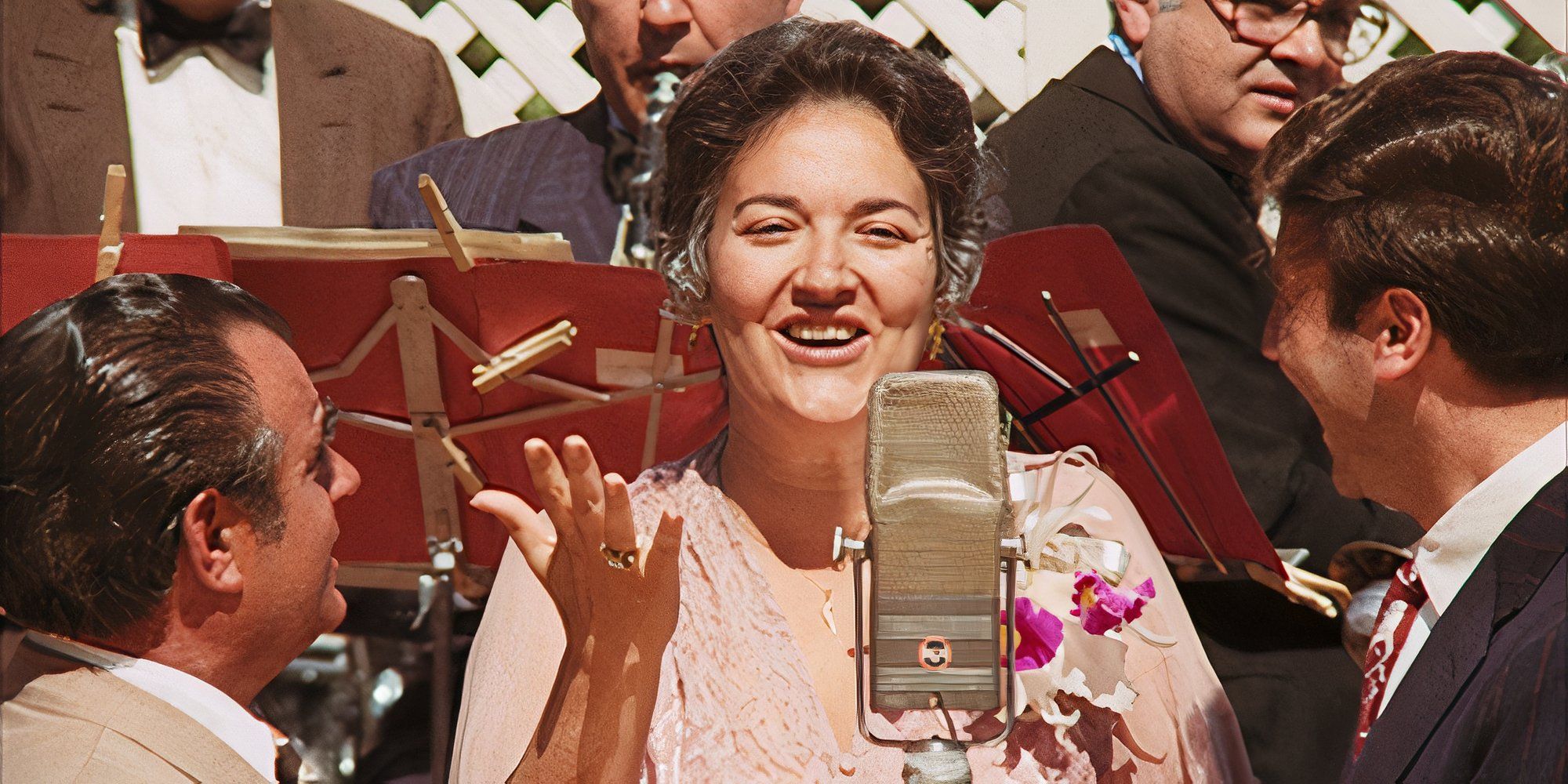 Morgana King as Carmela Corleone standing in front of a microphone singing in The Godfather (1972)