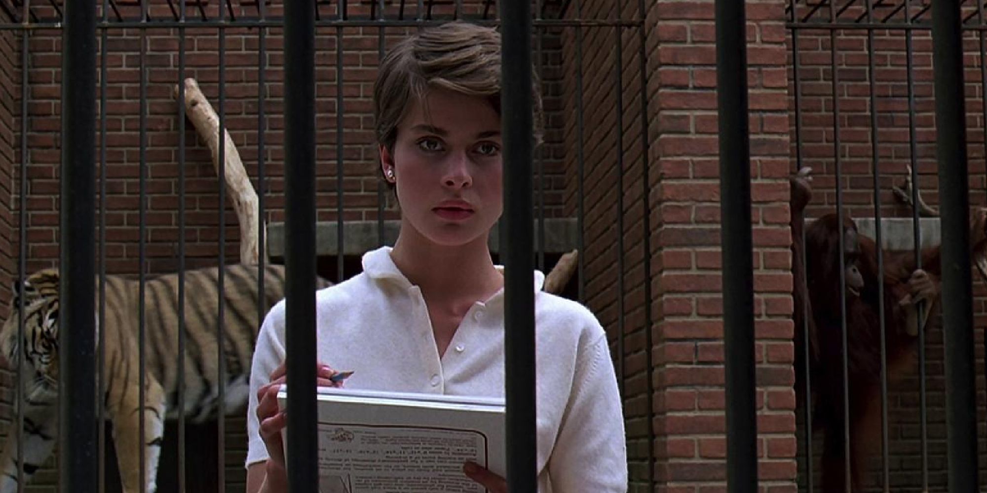 Nastassja Kinski as Irena in Cat People holding a book and a pen at a zoo