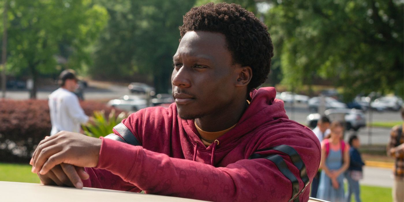 Okea Eme-Akwari as Shawn Payne leaning on a car roof in Cobra Kai Season 6 Part 1.
