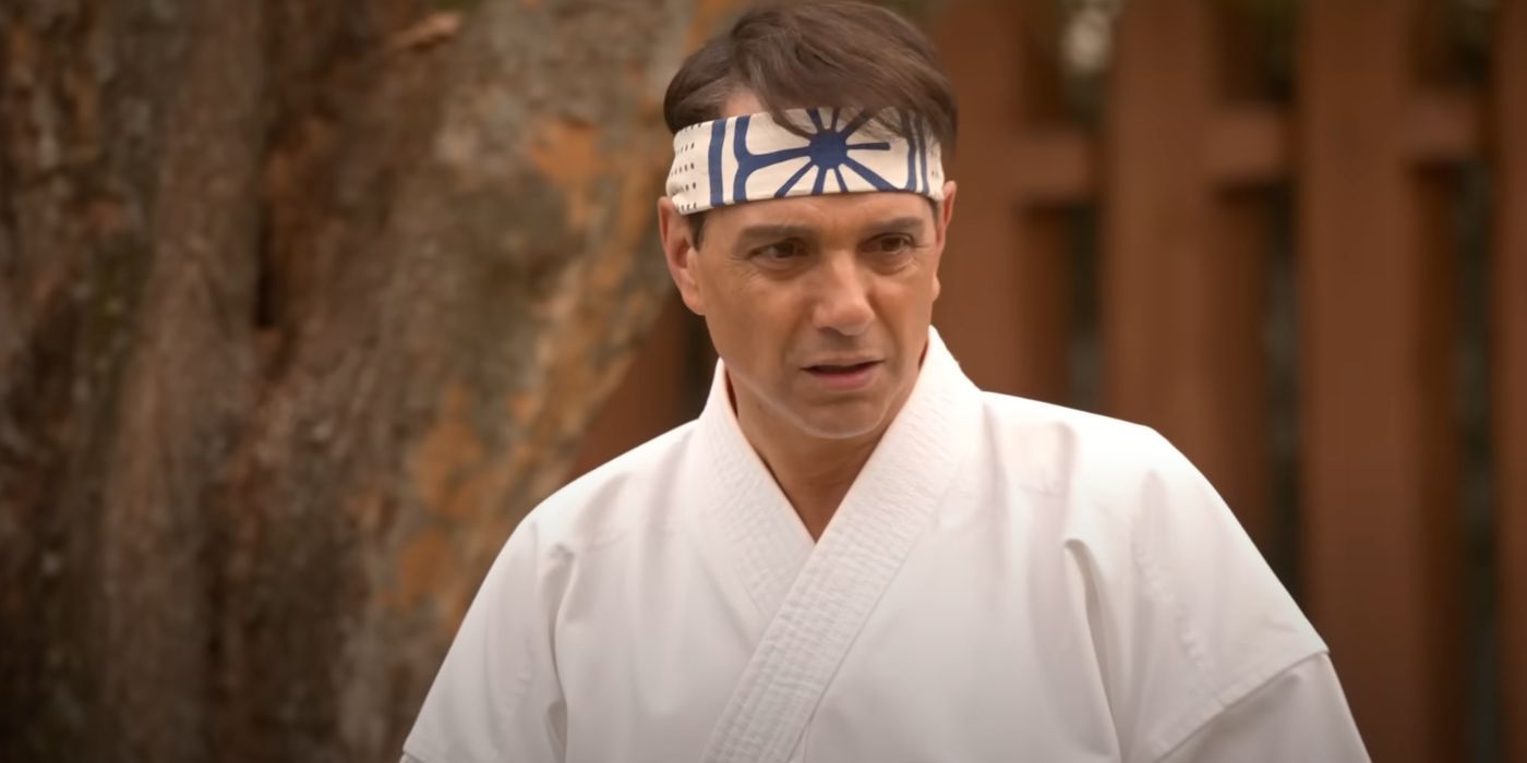 Ralph Macchio outside wearing a traditional karate headband as Daniel LaRusso.