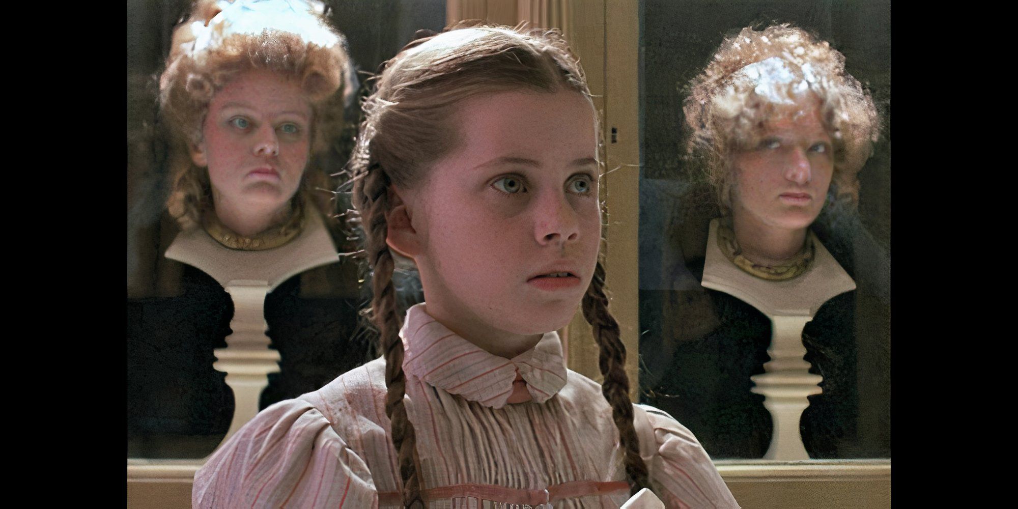 A young girl in braids with two women as statues behind her in Return to Oz