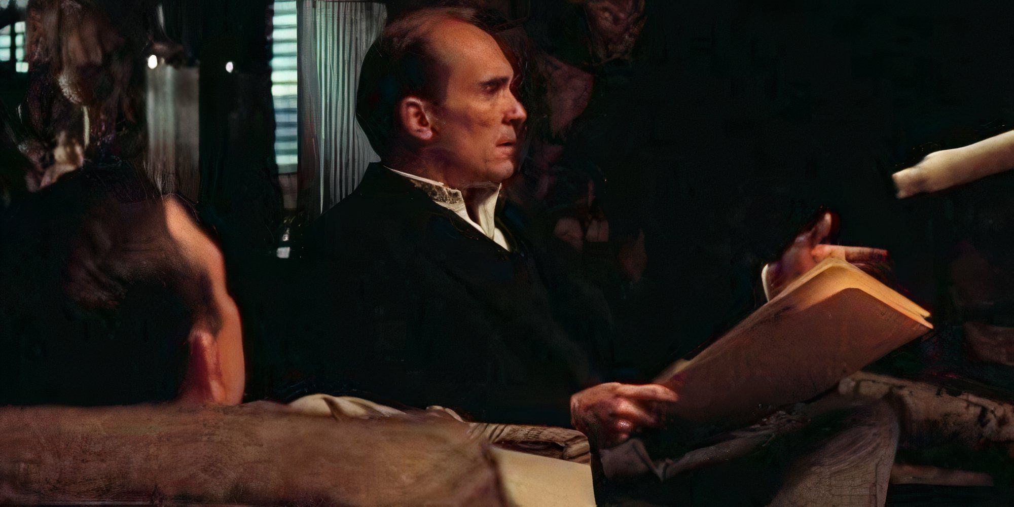 Robert Duvall as Tom Hagen sits with paperwork, talking to others, in The Godfather: Part II (1974)