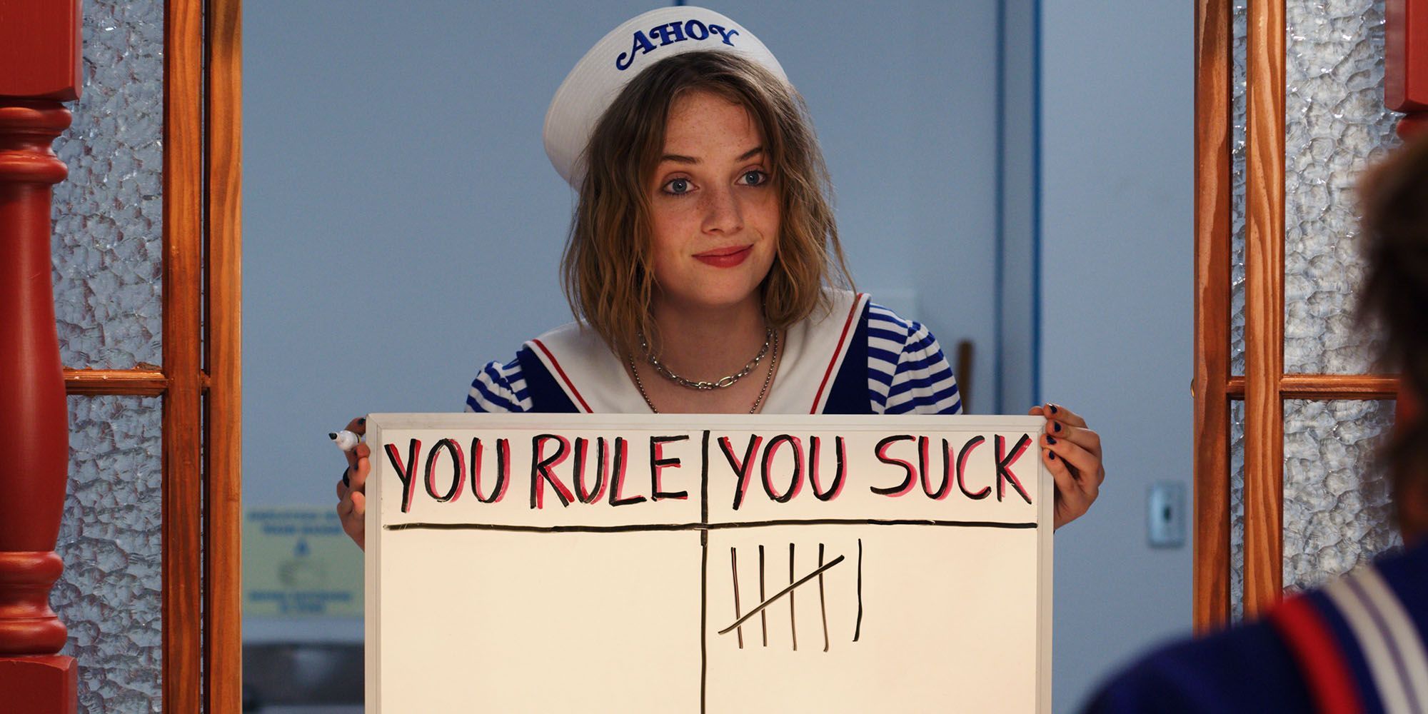 Robin holds up a tally she made for Steve. The left column titled &ldquo;You Rule&rdquo; has no marks. The right column titled &ldquo;You Suck&rdquo; has six marks in &lsquo;Stranger Things&rsquo;