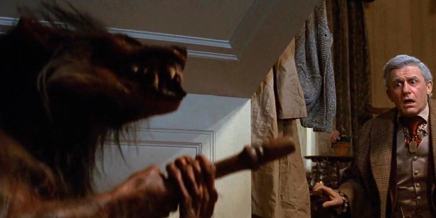 Roddy McDowall looking horrified at an impaled wolf creature under the stairs in Fright Night (1985)