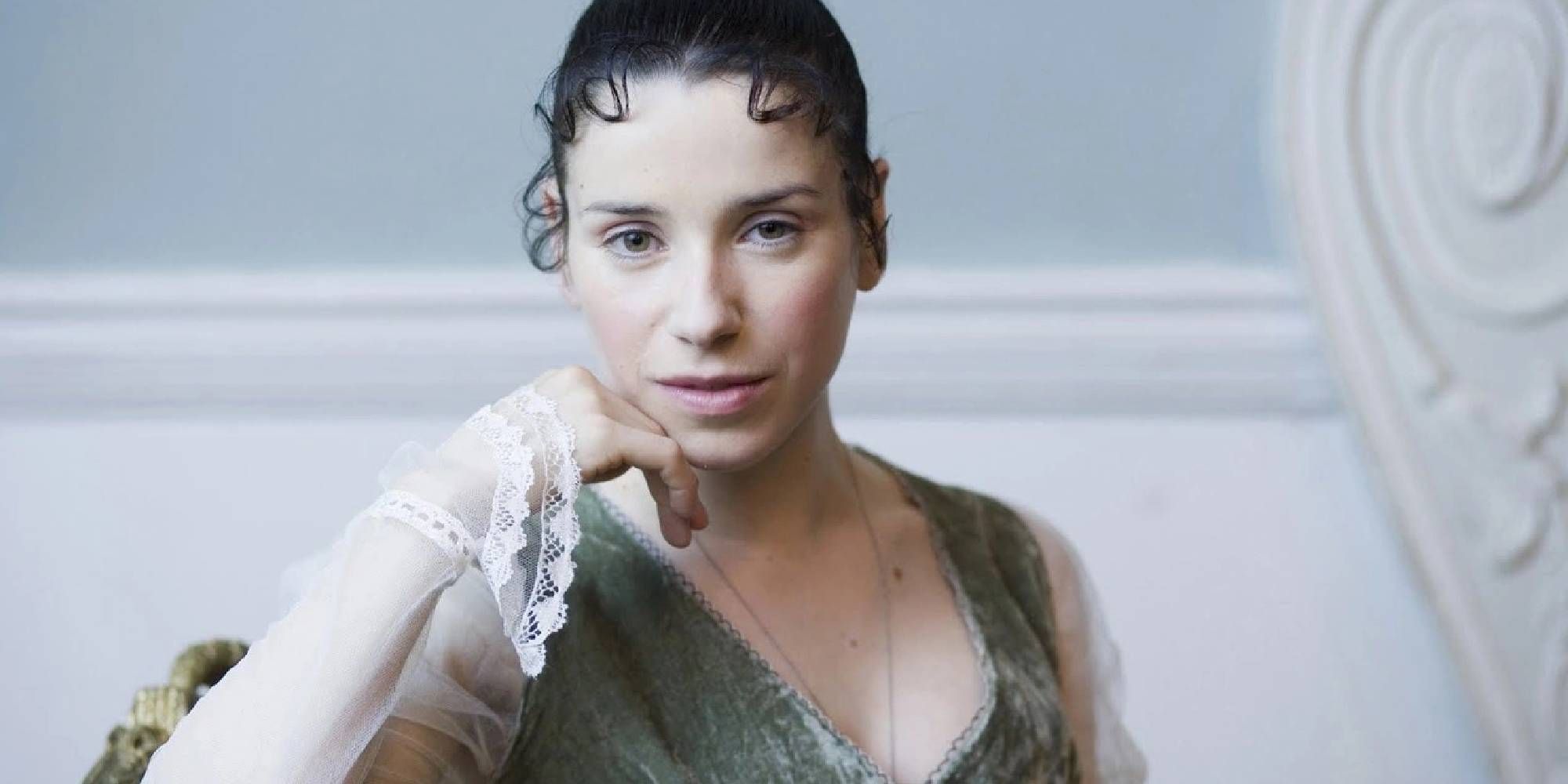 Sally Hawkins as Anne in Persuasion looking at the camera and smiling while sitting down.