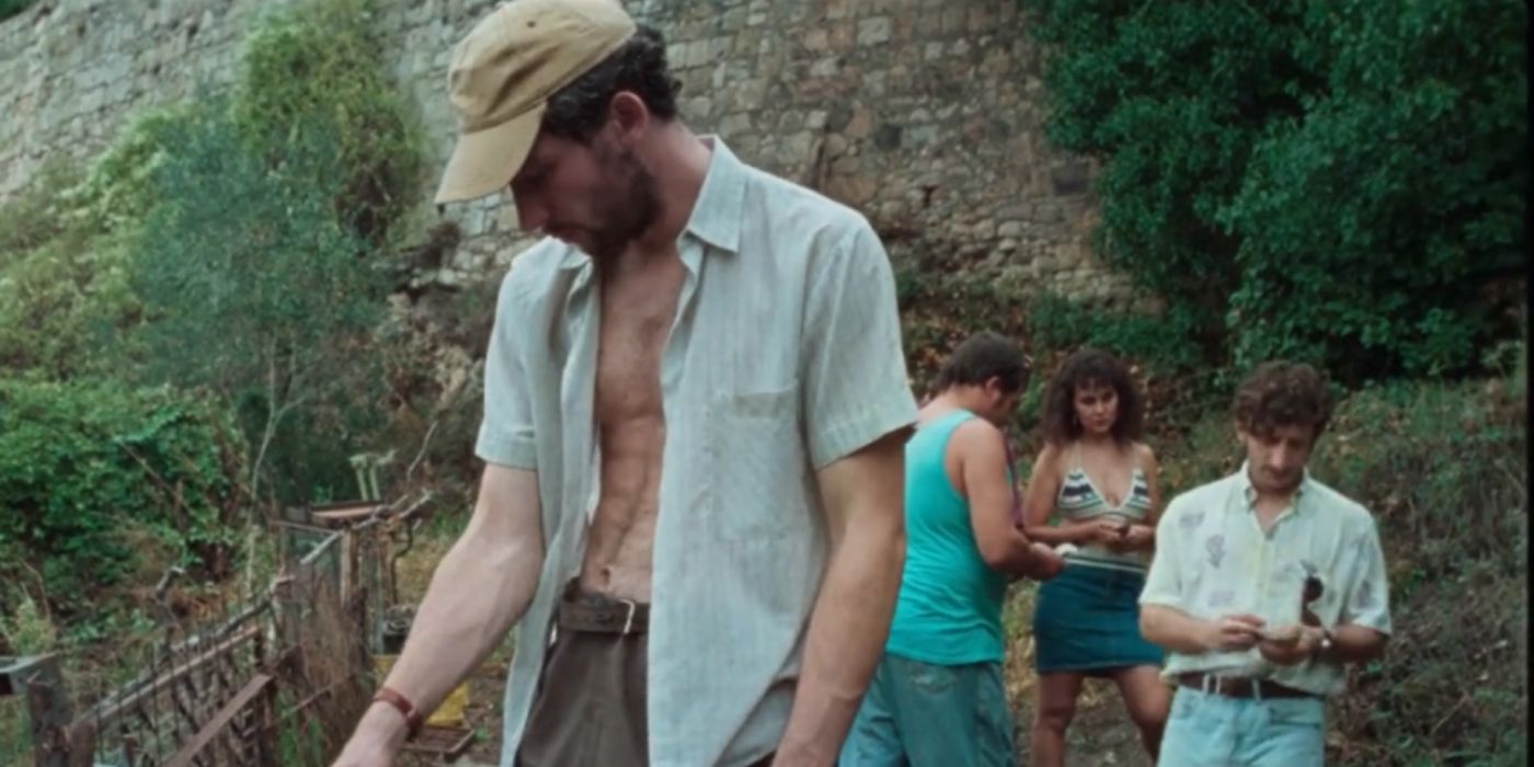 Josh O'Connor as Arthur shirtless wearing a baseball cap in 'La Chimera'