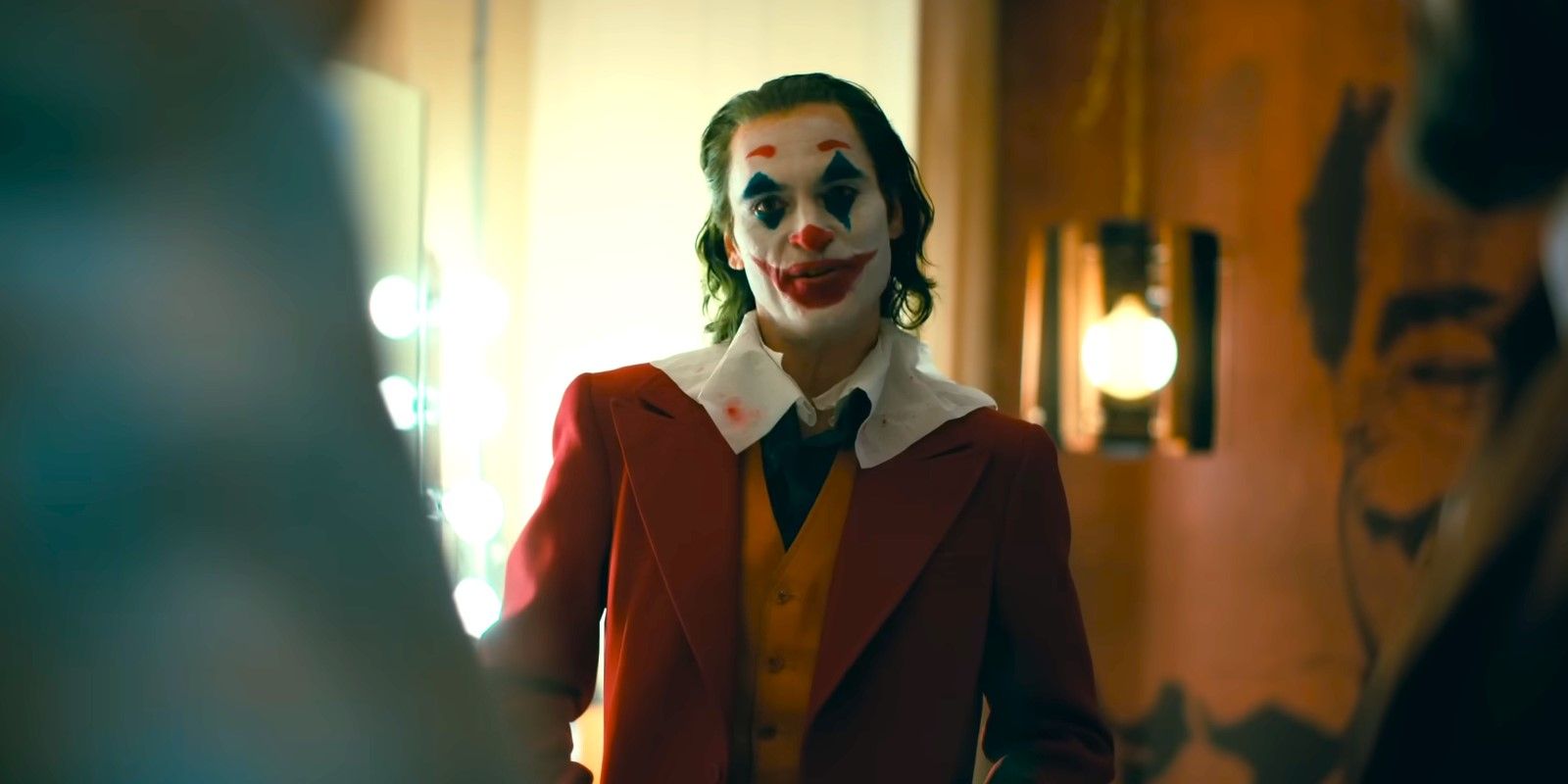 Joker staring at the camera in a dressing room in 2019's Joker.