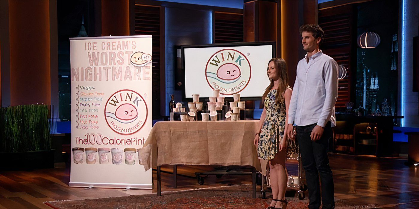 A man and a woman standing beside the Wink Frozen Desserts sign with various containers of treats behind them on Shark Tank.