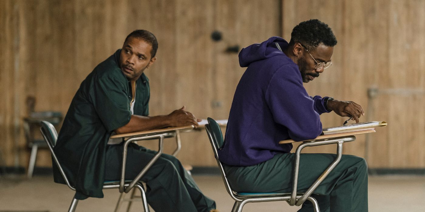 Clarence Maclin and Colman Domingo sitting in school desks in Sing Sing.