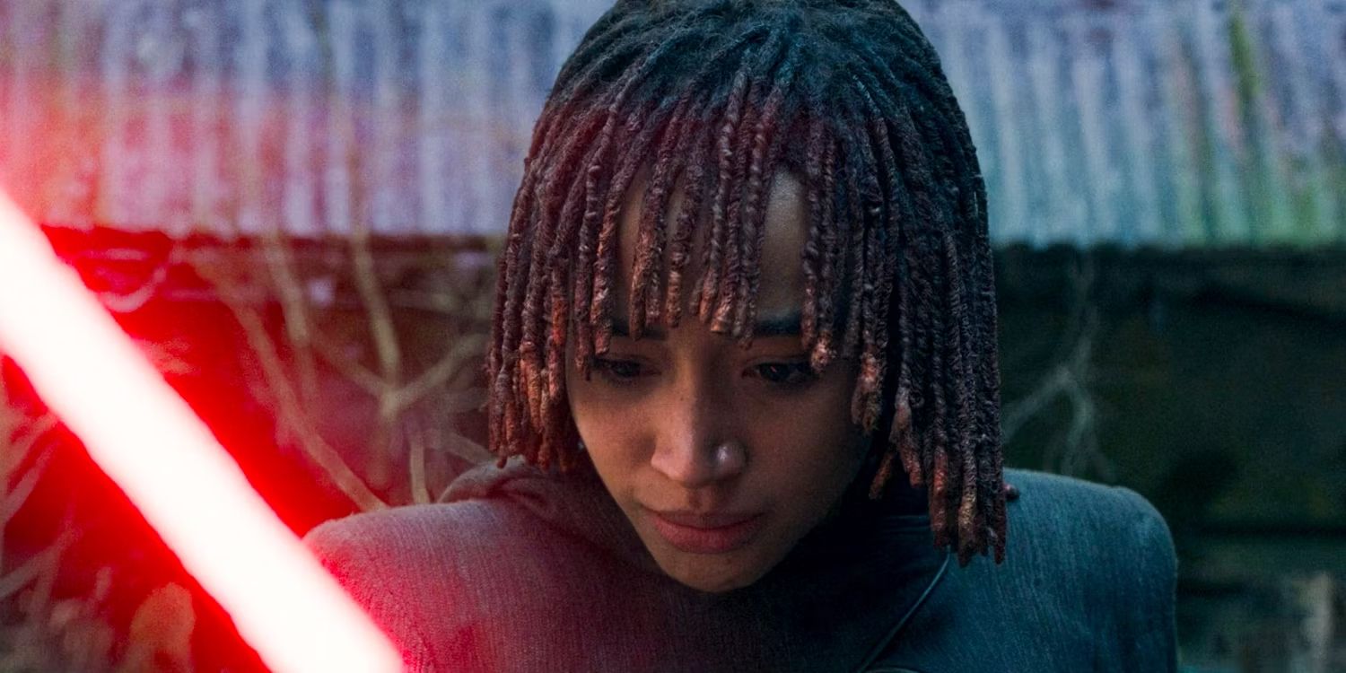 A close-up of Osha (Amandla Stenberg) staring down at her red lightsaber with a distressed expresssion in The Acolyte Episode 8