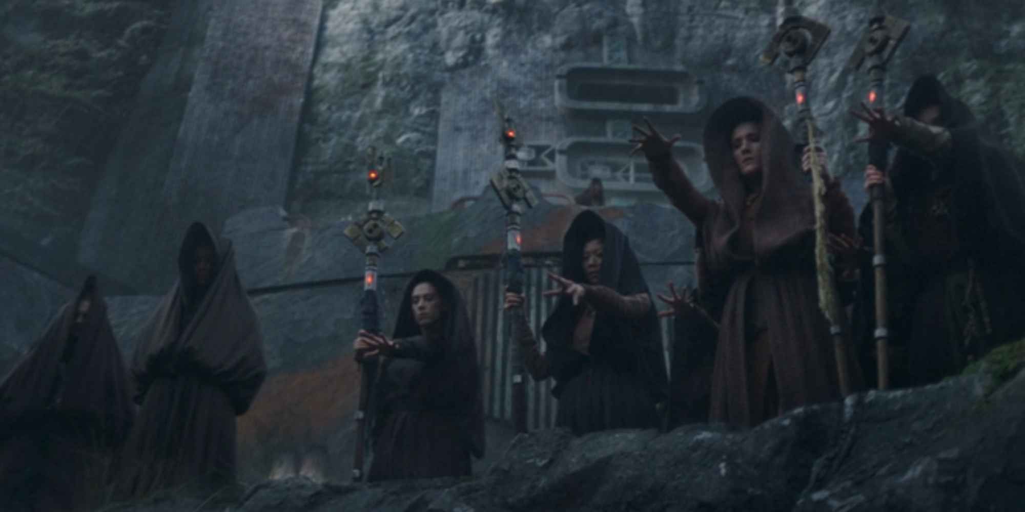 Several hooded witches on Brendok extending their arms in 'The Acolyte' Episode 7