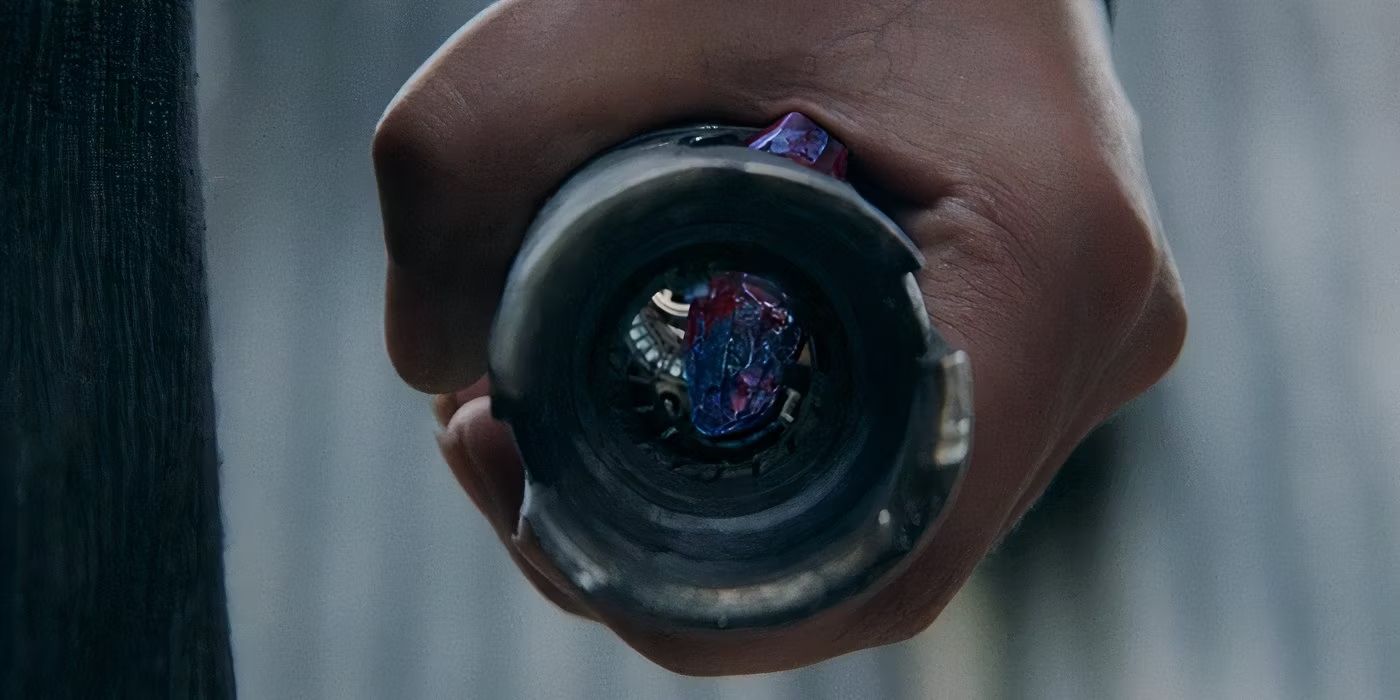 A close-up of Osha's (Amandla Stenberg) hand clutching Sol's lightsaber and bleeding the blue kyber crystal inside red in The Acolyte Episode 8