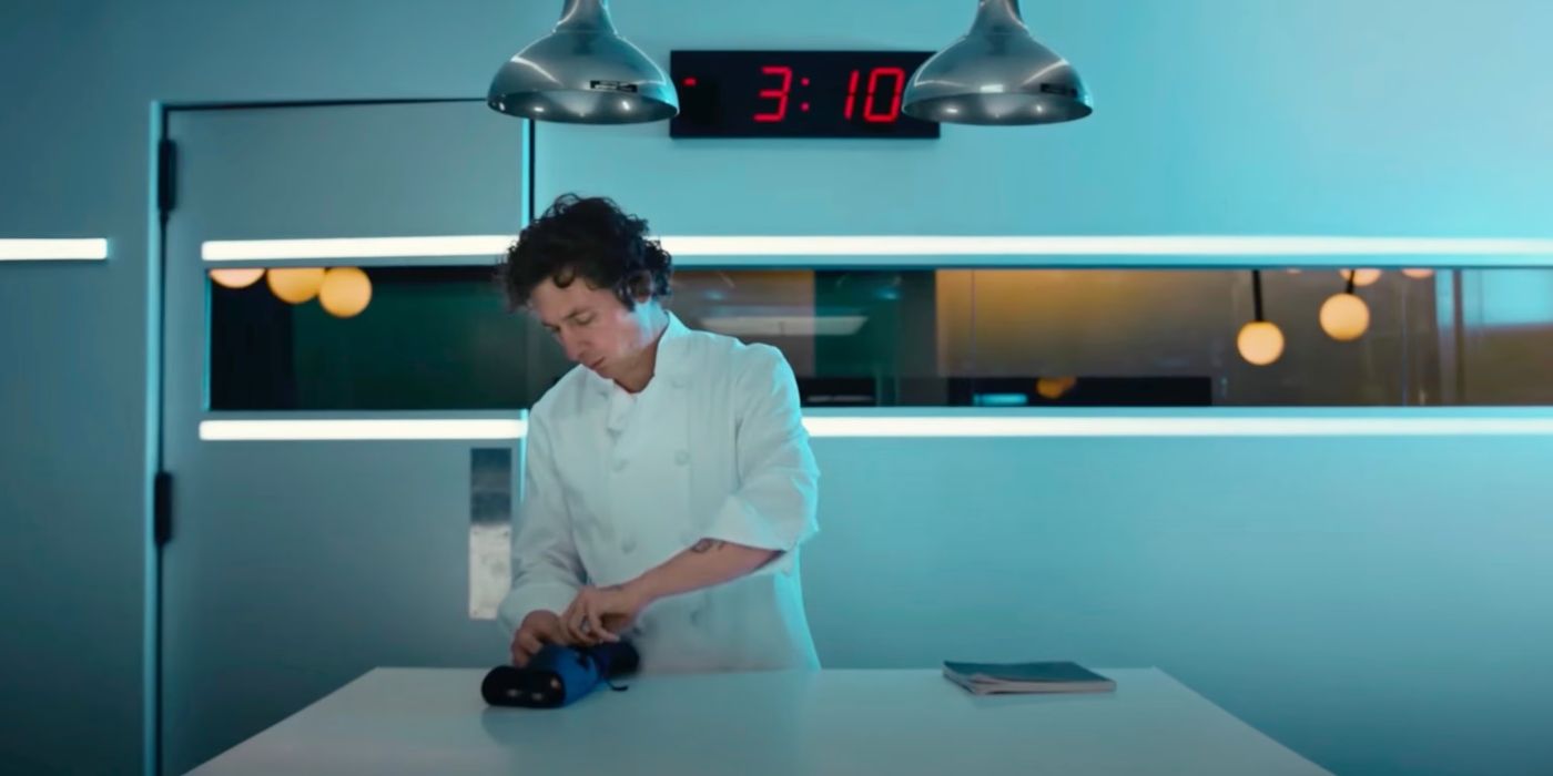 Carmy in a white chef coat standing in the kitchen with a digital countdown behind him in 'The Bear.'