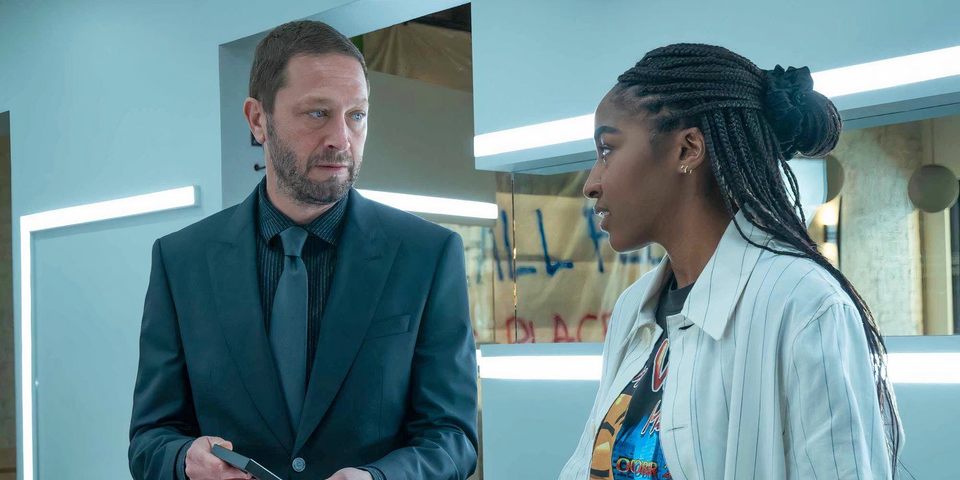Ritchie (Ebon Moss-Bachrach) wearing a suit and talking to Sydney (Ayo Edebiri) in the kitchen in The Bear.