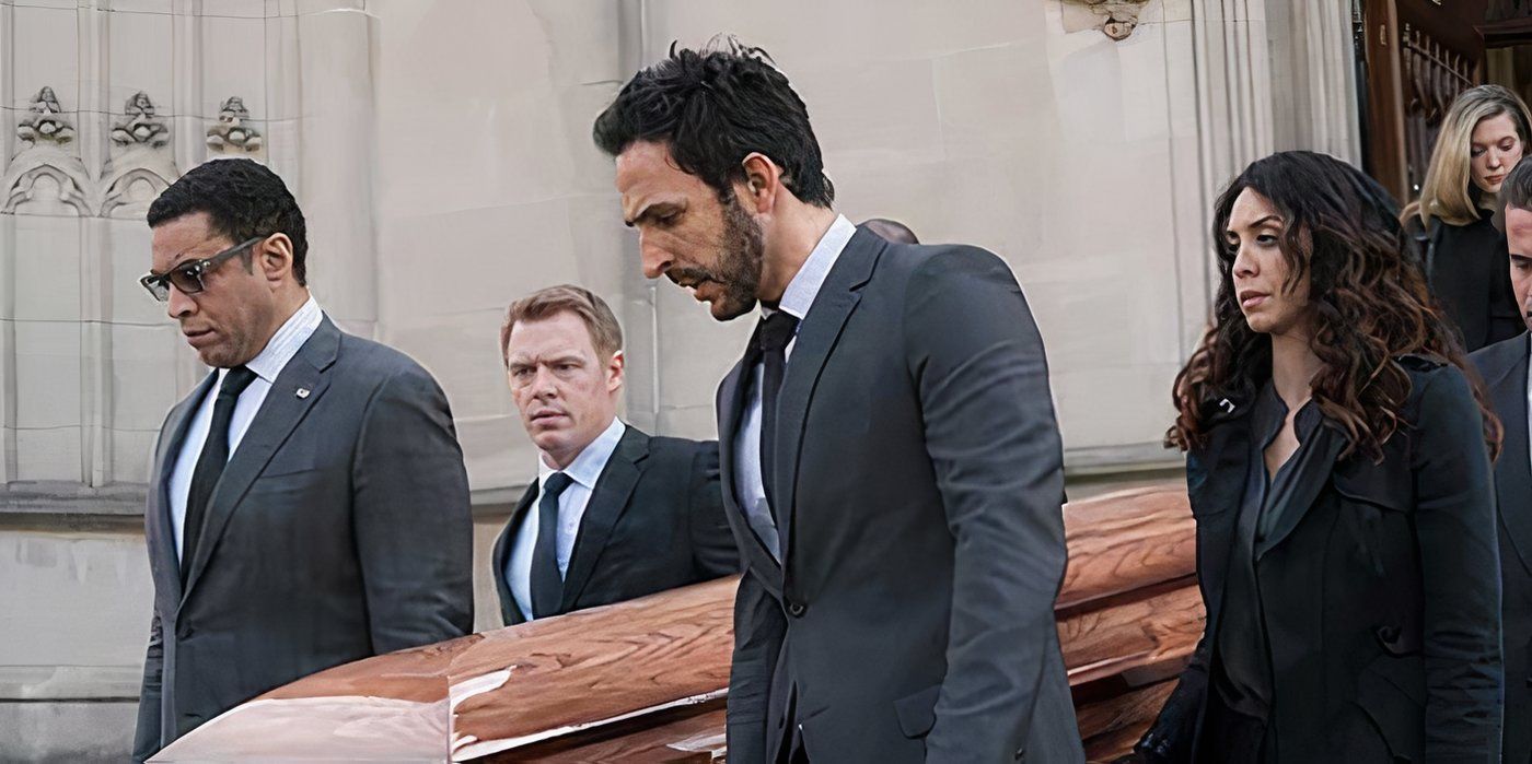 Co-workers looking somber, carrying Liz&rsquo;s coffin out of a church on The Blacklist