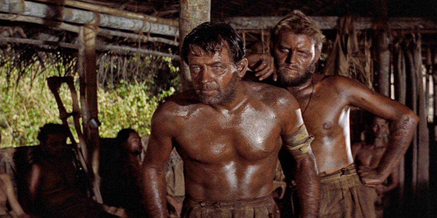 Two shirtless men looking intently ahead in The Bridge on the River Kwai