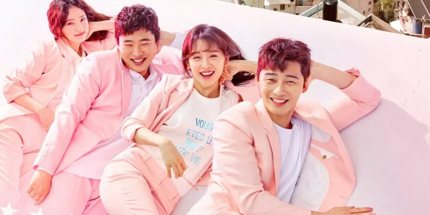 The cast of Fight for My Way pose together in matching pastel blazers lying on the roof of a building.