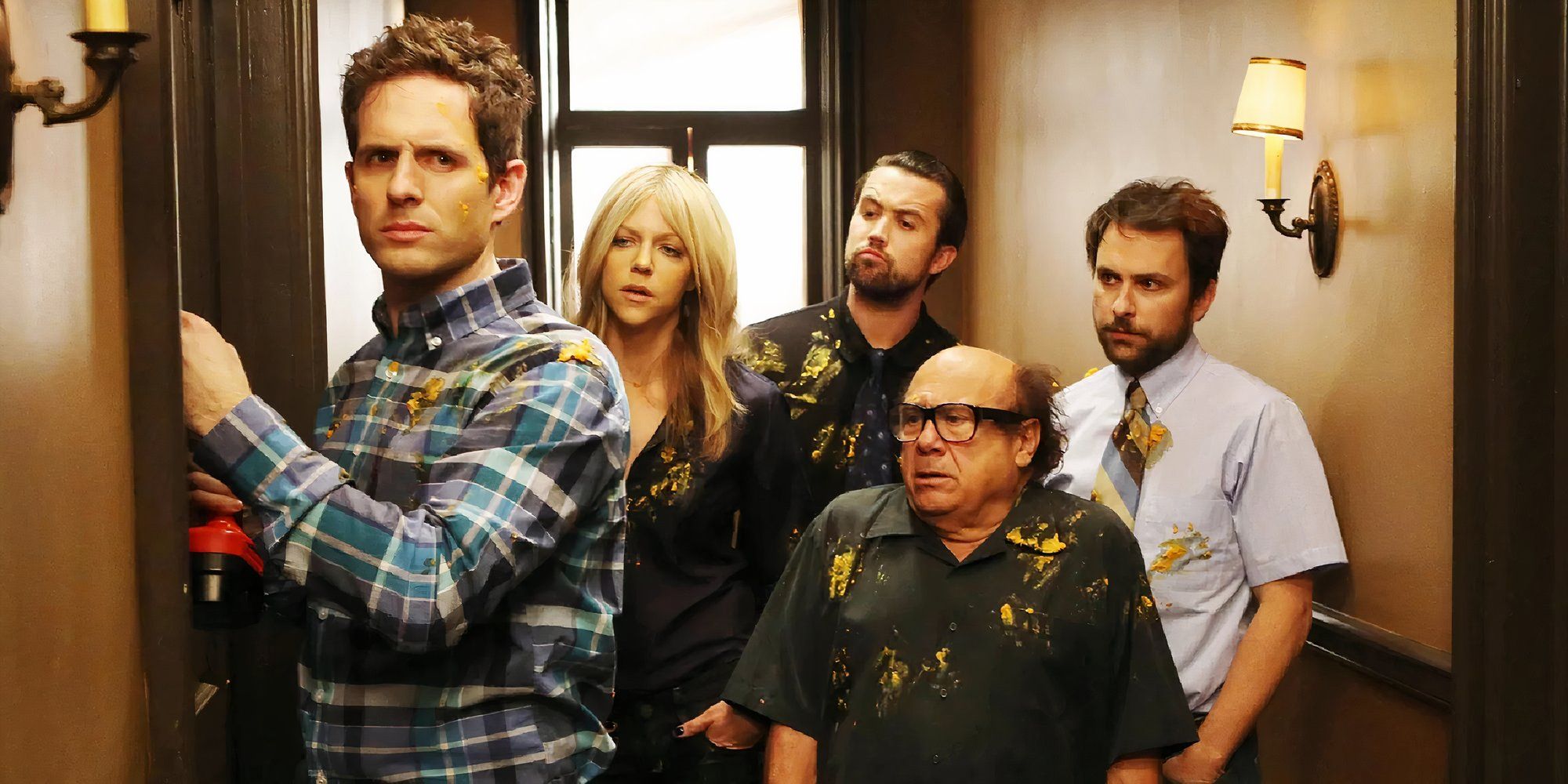 The cast of It's Always Sunny in Philadelphia standing in a hallway