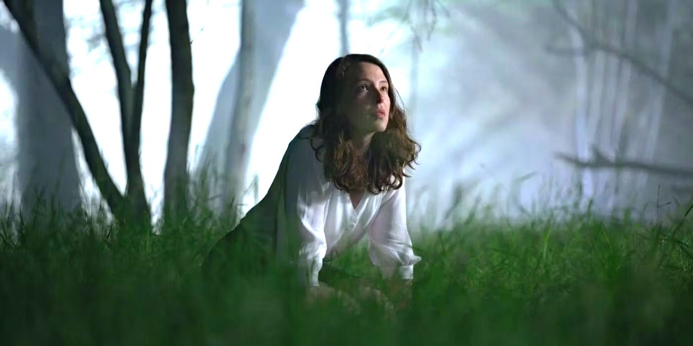 Cady from 'The Feast' kneels in the grass. 