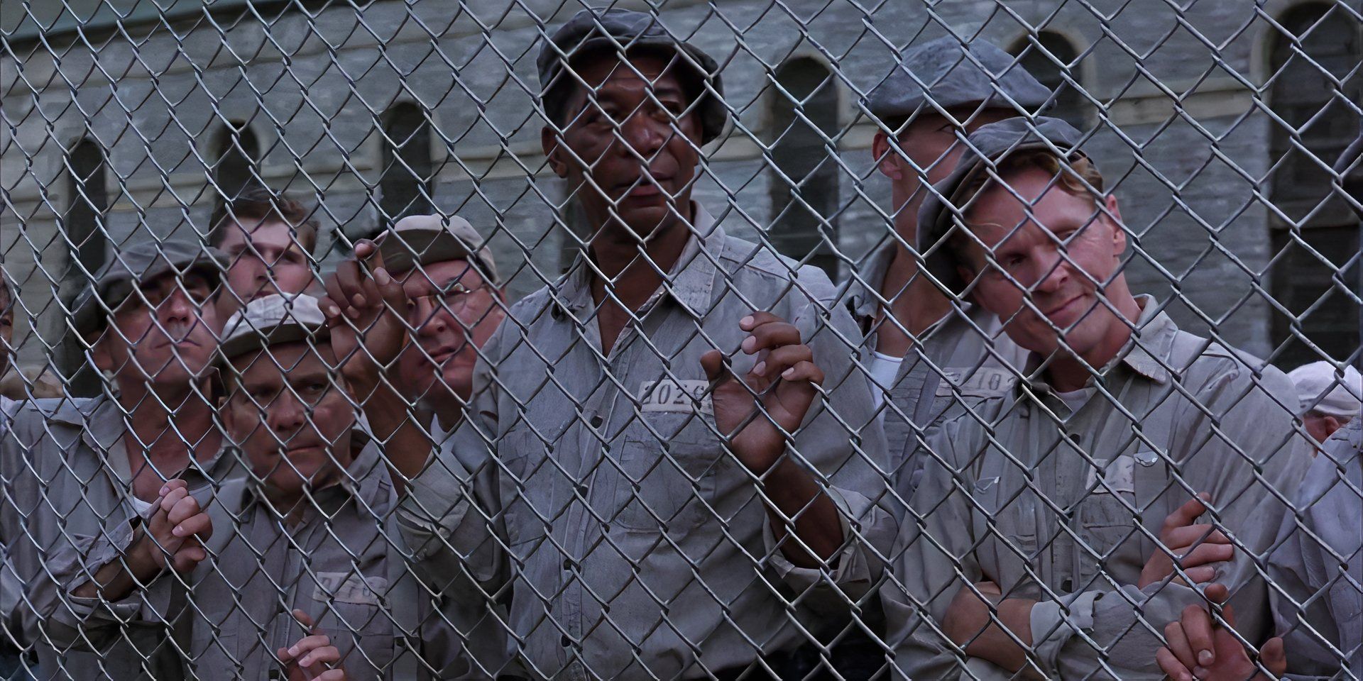 A group of inmates looking from behind a fence in The Shawshank Redemption