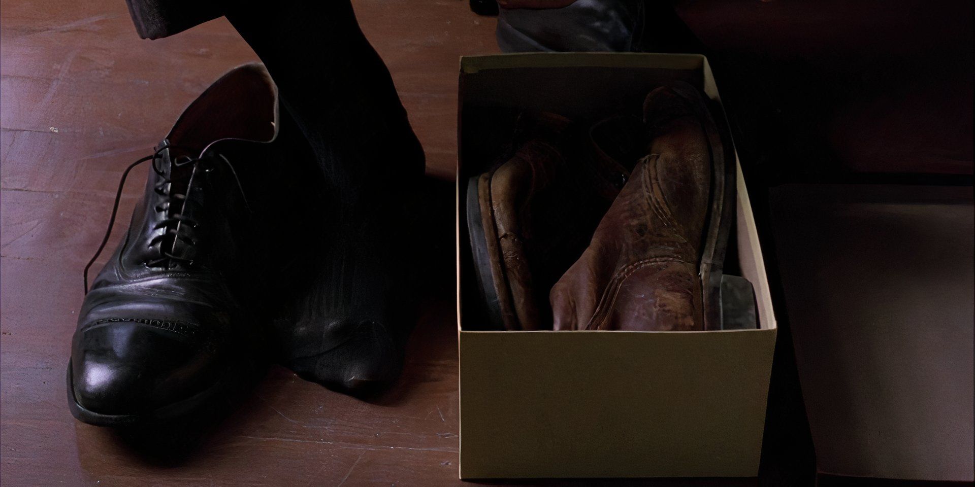 A-nice-black-shoe-next-to-a-black-sock-and-a-shoe-box-with-two-worn-brown-shoes