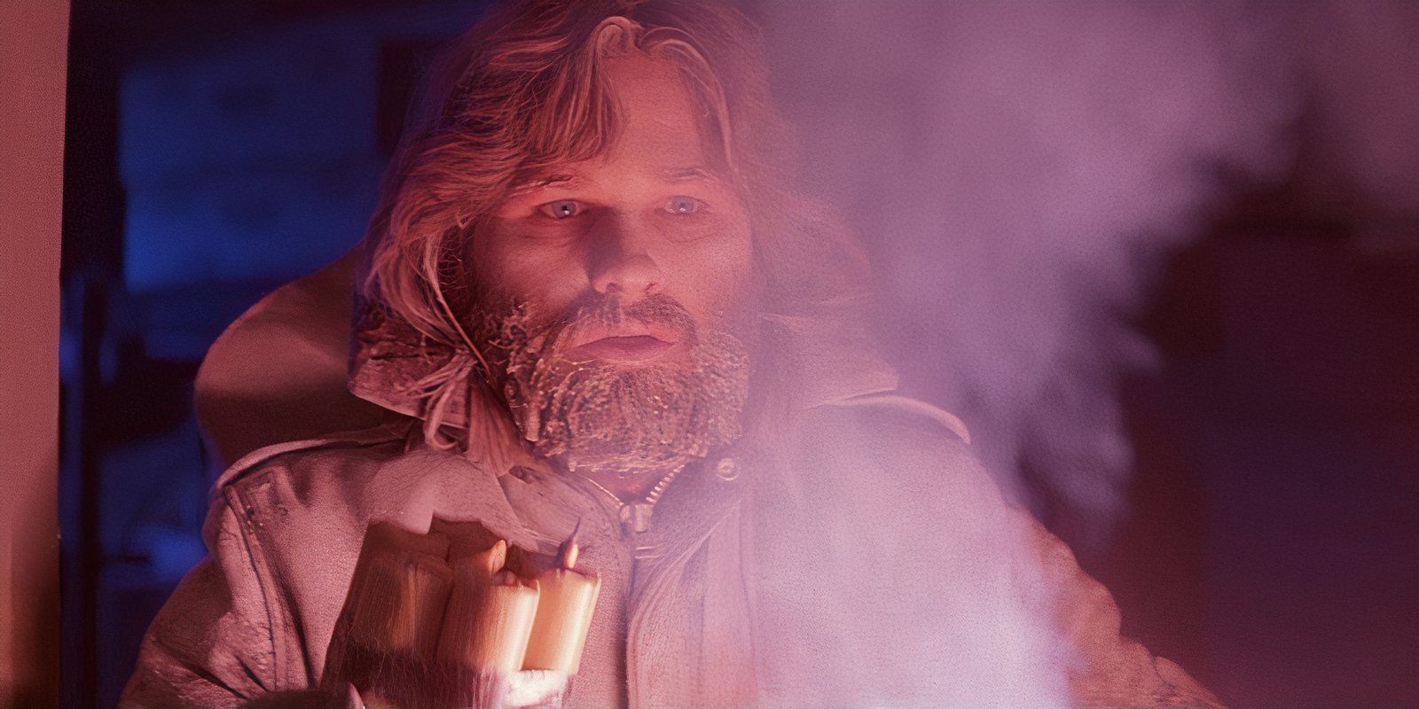 Macready iluminated by a red light while holding sticks of dynamite in The Thing.