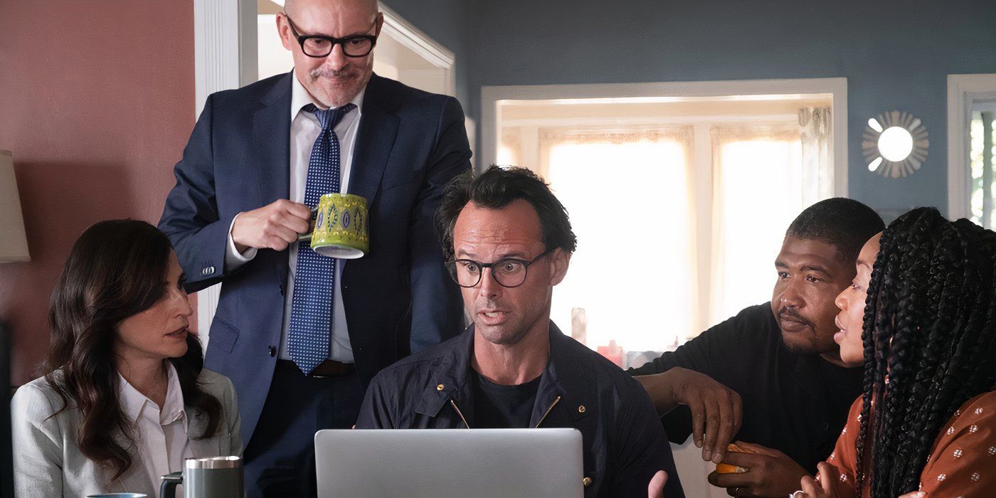A man sits behind a computer surrounded by friends in a scene from The Unicorn.