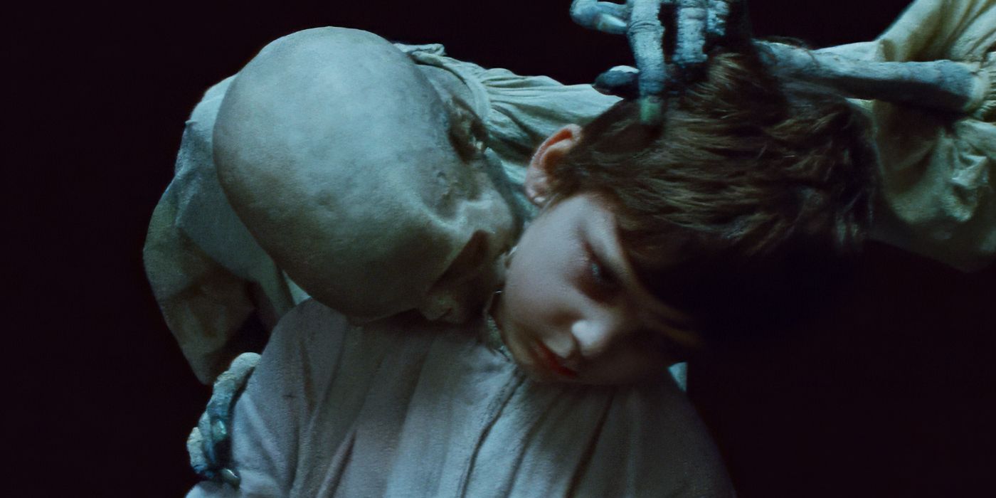 A vampire shrouded in darkness bites into the neck of a child in The Vourdalak.