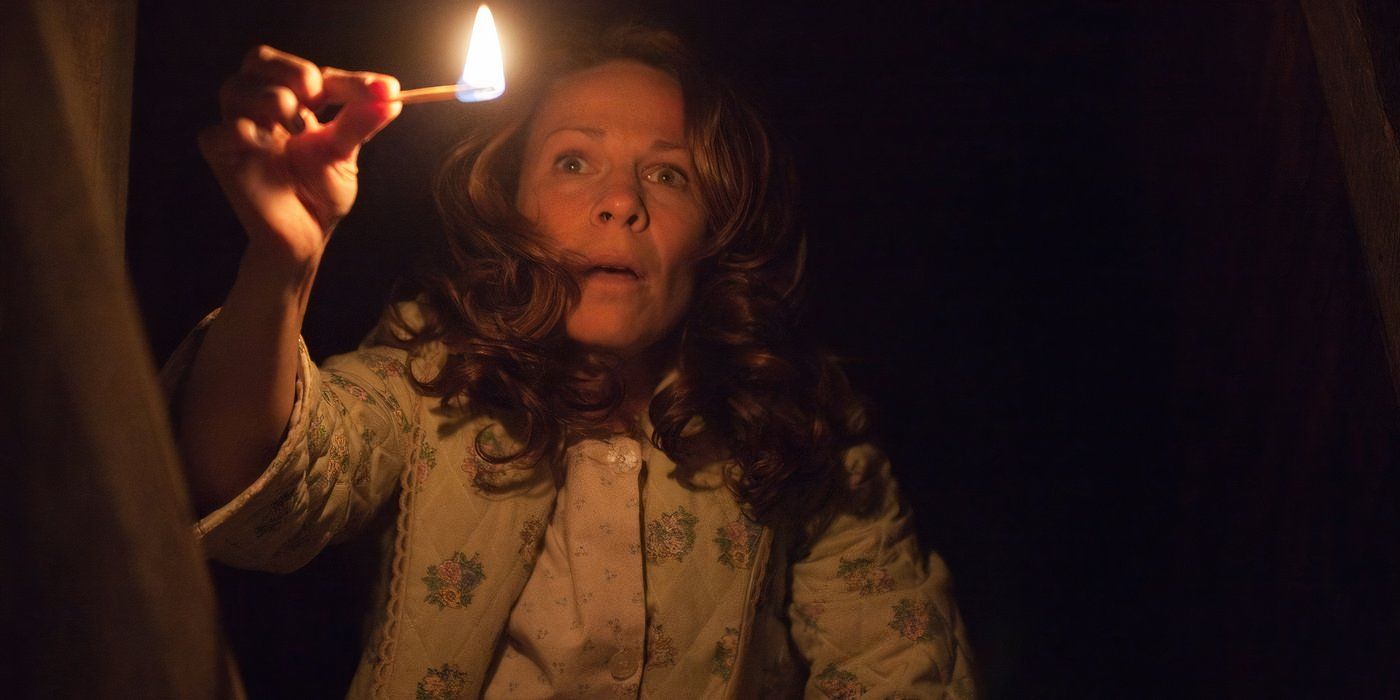 Carolyn Perron (Lili Taylor) holds a lit match in the dark in 'The Conjuring.'