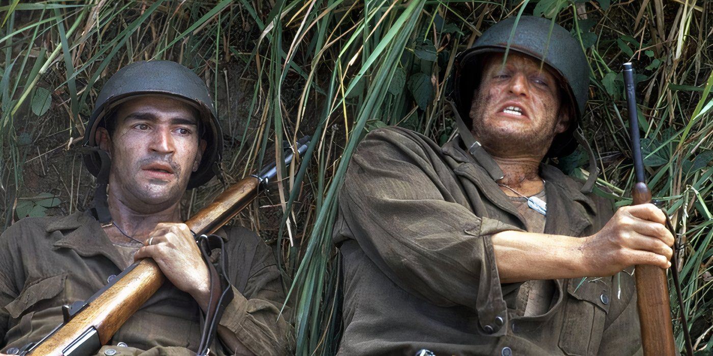 Two American soldiers hold their rifles close and lie on their backs in tall grass in 'The Thin Red Line'