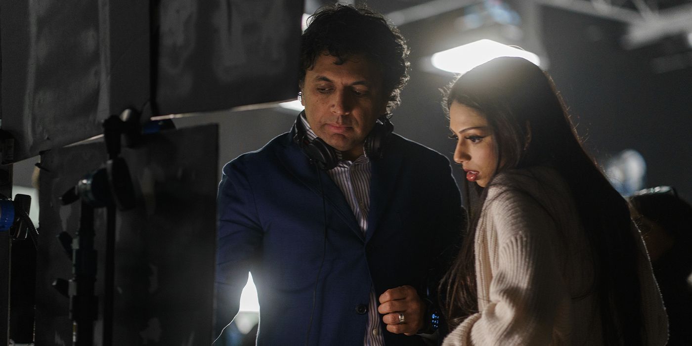 M. Night Shyamalan shows Saleka Shyamalan something on the monitor on the set of Trap