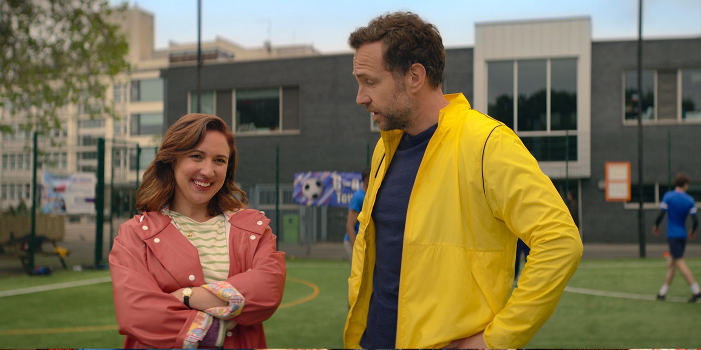 Esther Smith smiles while Rafe Spall talks to her in a scene from Trying Season 4.