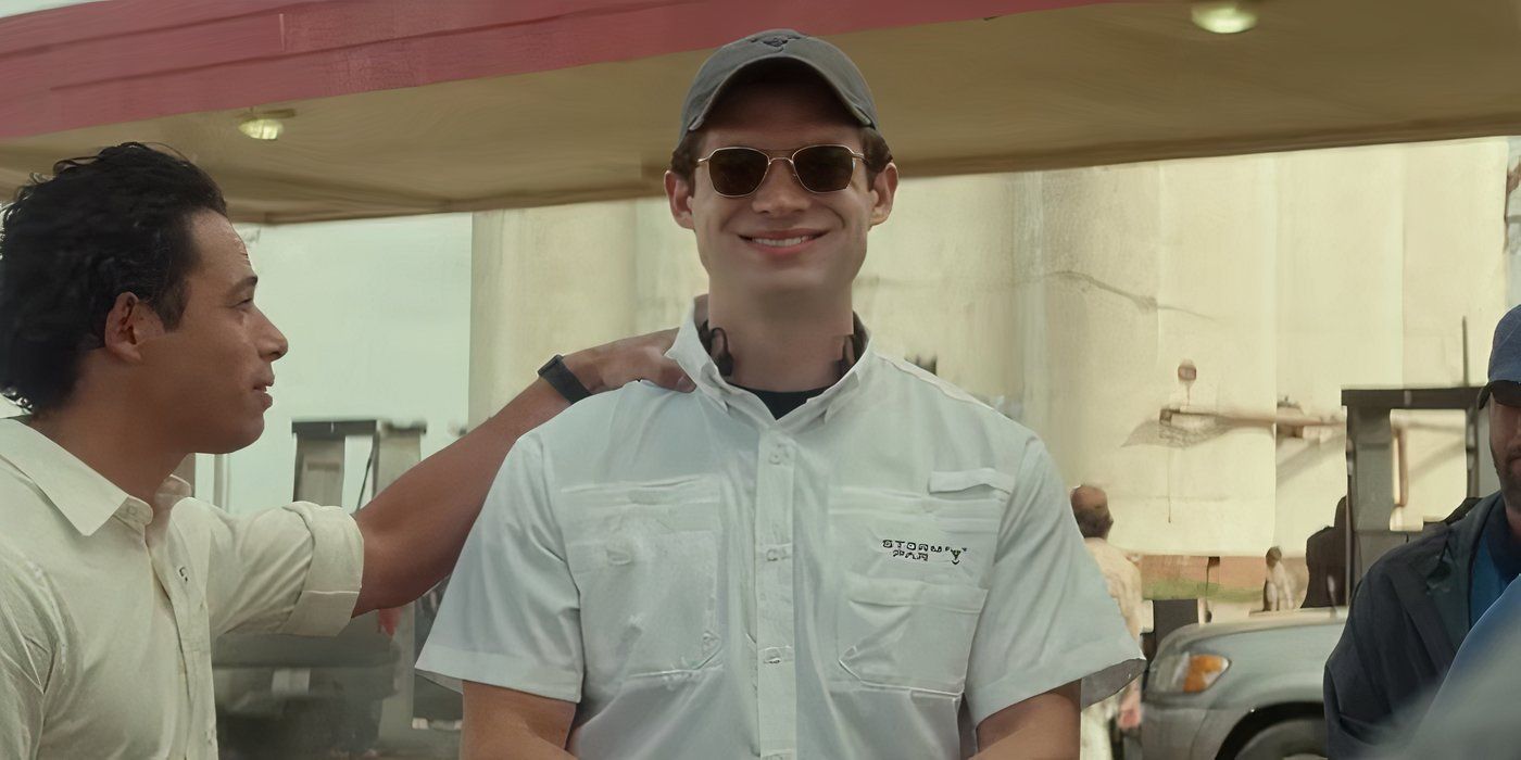 David Corenswet as Scott wearing sunglasses and a baseball cap smiling toward the camera